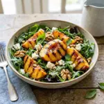 Delicious grilled peach salad with fresh greens and toppings.